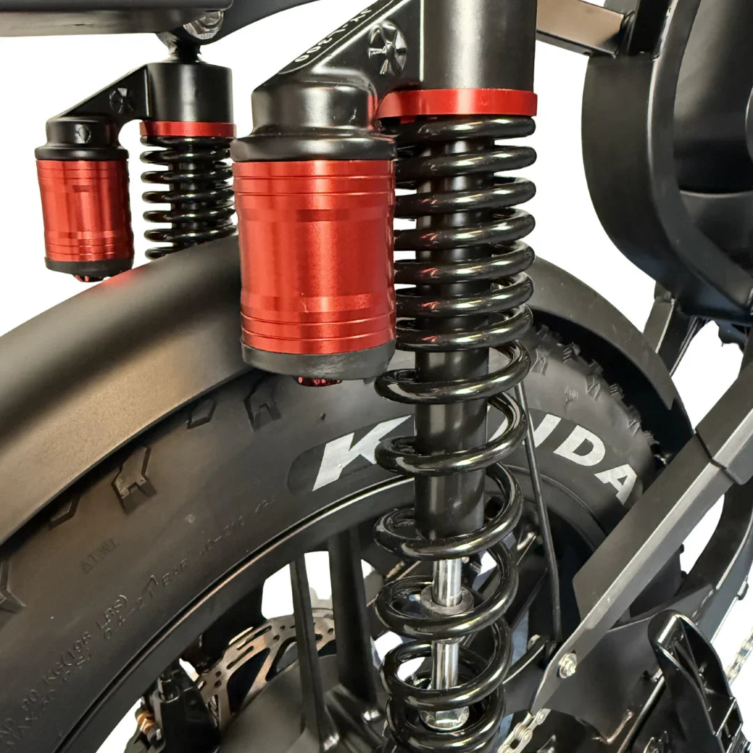 QMWheel V29 Pro Doppelakku Fatbike in Schwarz, Nahaufnahme der Hinterradfederung mit roten Stoßdämpfern